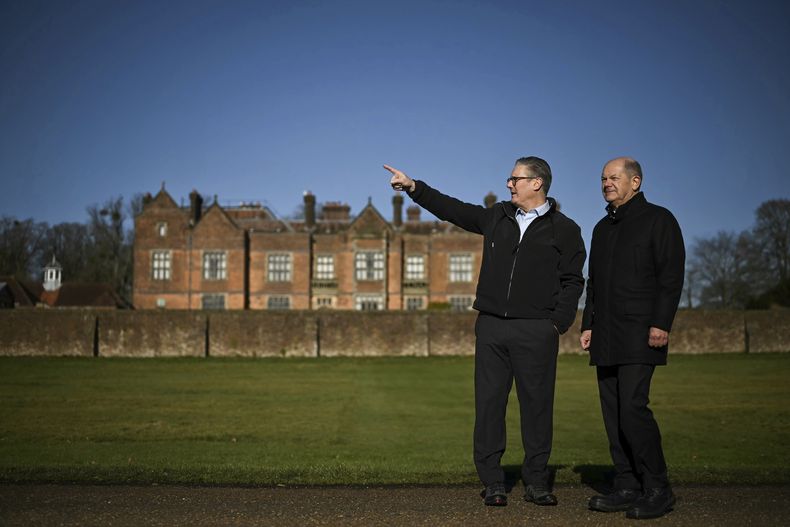 El primer ministro británico, Keir Starmer, a la izquierda, habla con el canciller de Alemania, Olaf Scholz, mientras dan un paseo por el jardín de Chequers, en Aylesbury, Inglaterra, el domingo 2 de febrero de 2025. (Ben Stansall/Pool Photo vía AP)
