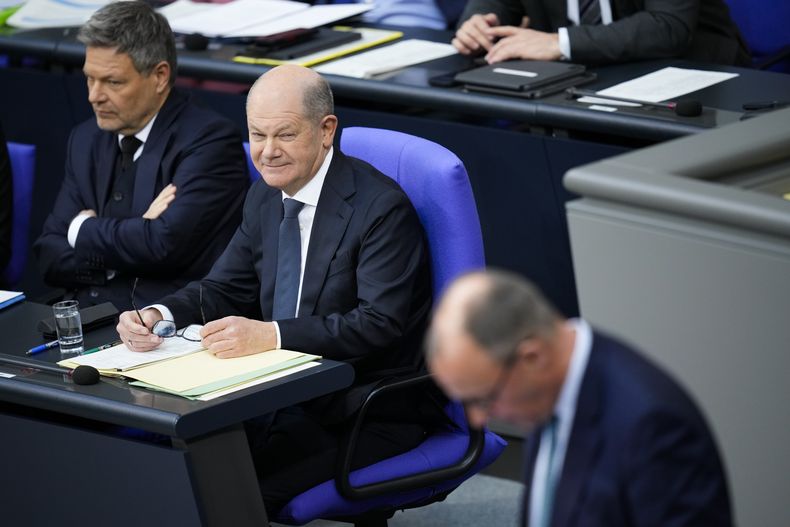 El canciller de Alemania, Olaf Scholz, en el centro, y el vicecanciller y ministro de economía y clima, Robert Habeck, a la izquierda, escuchan al líder de los partidos cristianos en la cámara y candidato a canciller, Friedrich Merz, a la derecha, durante la última sesión parlamentaria antes de las elecciones nacionales, en el Bundestag de Berlín, Alemania, el martes 11 de febrero de 2025. (AP Foto/Ebrahim Noroozi)
