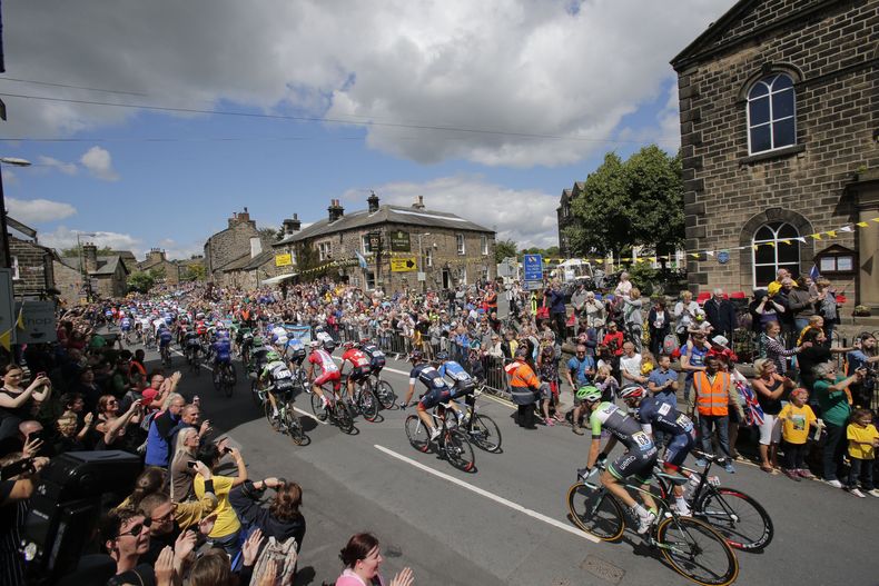 ARCHIVO - Los espectadores observan el paso del pelotón en la primera etapa del Tour de Francia, el sábado 5 de julio de 2014, con salida en Leeds y meta en Harrogate, Inglaterra. (AP Foto/Christophe Ena)