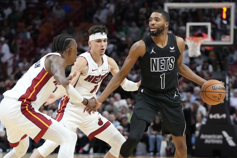 Mikal Bridges, alero de los Nets de Brooklyn, busca enviar un pase frente a Josh Richardson (izquierda) y Tyler Herro (centro), del Heat de Miami, en el partido del miércoles 1 de noviembre de 2023 (AP Foto/Wilfredo Lee)