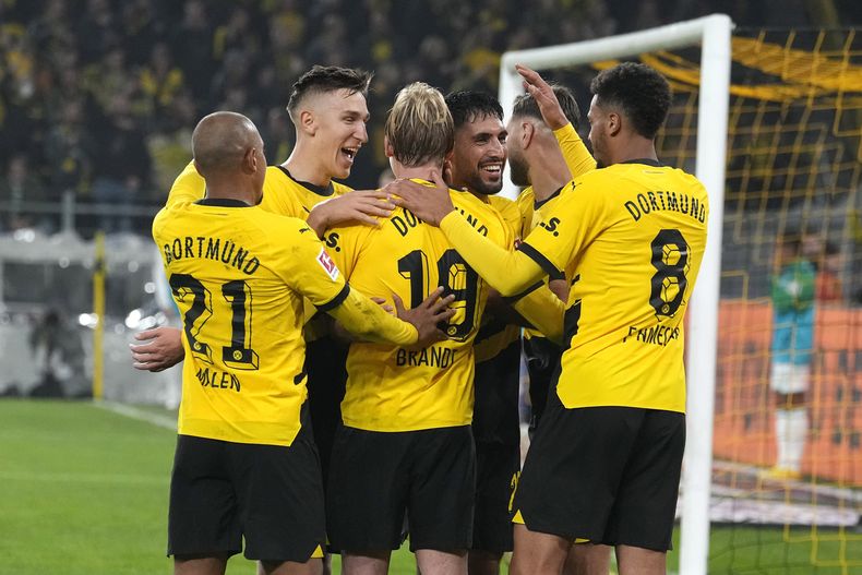 Julian Brandt del Borussia Dortmund es felicitado por sus compañeros tras anotar en el encuentro de la Bundesliga ante el Werder Bremen el viernes 20 de octubre del 2023. (AP Foto/Martin Meissner)