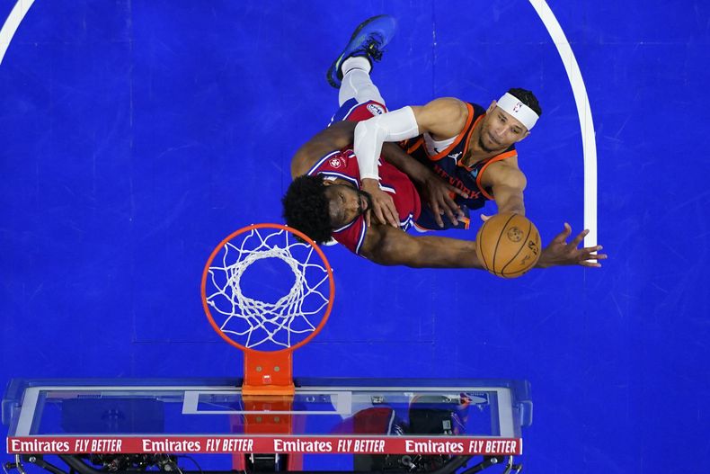 Josh Hart, de los Knicks de Nueva York, a la derecha, tira frente a Joel Embiid, de los 76ers de Filadelfia, durante la segunda mitad del Juego 4 en una serie de playoffs de primera ronda de baloncesto de la NBA, el domingo 28 de abril de 2024, en Filadelfia. (AP Foto/Matt Slocum)