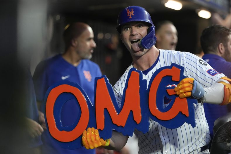 Pete Alonso, de los Mets de Nueva York, celebra con un cartel de OMG (¡Oh Dios Mío) en el dugout después de batear un jonrón durante la cuarta entrada del juego de béisbol en contra de los Mellizos de Minnesota, el lunes 29 de julio de 2024, en Nueva York. (AP Foto/Pamela Smith)