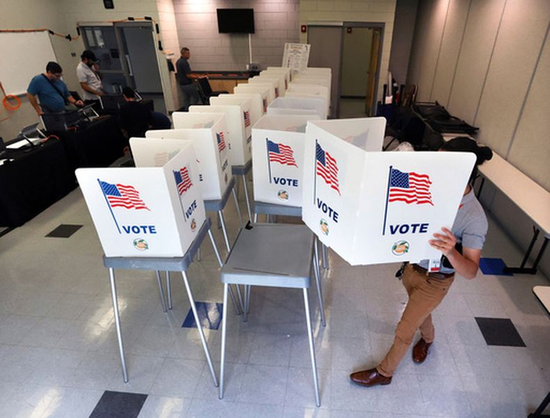 ARCHIVO - Lenny Carrillo, de la Oficina del Supervisor de Elecciones del Condado Orange, instala las cabinas de votación en el Centro Comunitario Meadow Woods en Orlando, Florida, el 15 de octubre de 2024. (Joe Burbank/Orlando Sentinel vía AP, archivo)