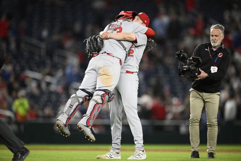 El abridor Erick Fedde, centro, de los Cardenales de San Luis, alza al receptor Pedro Pagés, izquierda, después de completar un juego de béisbol de Grandes Ligas por blanqueada frente a los Nacionales de Washington, el viernes 9 de mayo de 2025, en Washington. (AP Foto/Nick Wass)