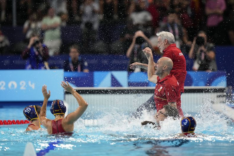 El cuerpo técnico de la selección femenina de polo acuático salta a la piscina tras ganar la final olímpica ante Australia, el sábado 10 de agosto de 2024, en París (AP Foto/Luca Bruno)