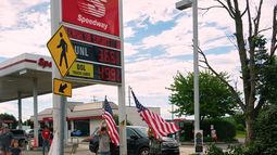 Dos niños ondean banderas de Estados Unidos en una gasolinera mientras la caravana presidencial de Donald Trump pasa frente a ella, el martes 23 de junio de 2026, en Pensilvania. (AP Foto/Julia Demaree Nikhinson)
