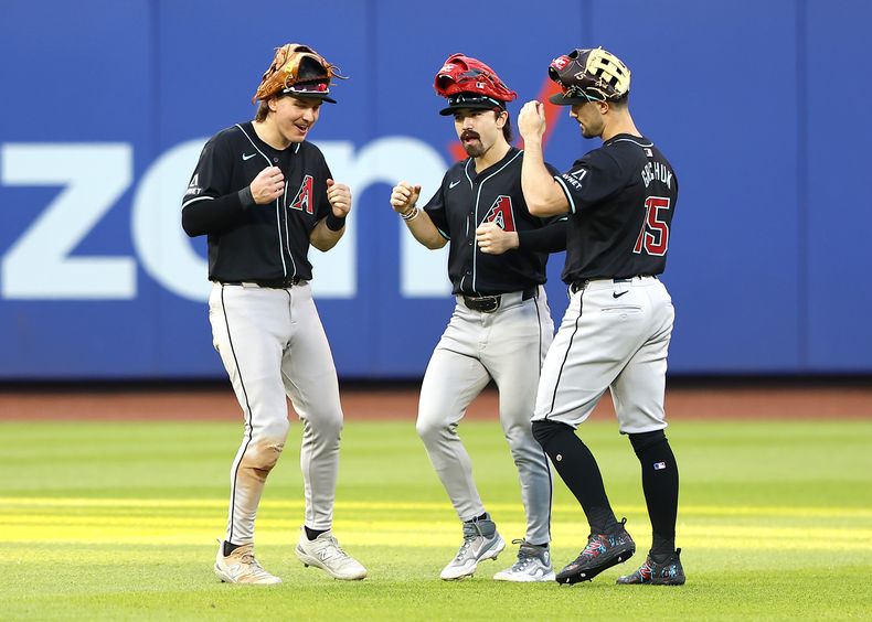 Los jardineros de los Diamondbacks de Arizona, de izquierda a derecha, Corbin Carroll, Jake McCarthy y Randal Grichuk (15) celebran después de derrotar 10-5 a los Mets de Nueva York en un juego de béisbol, el sábado 1 de junio de 2024, en Nueva York. (AP Foto/Noah K. Murray)