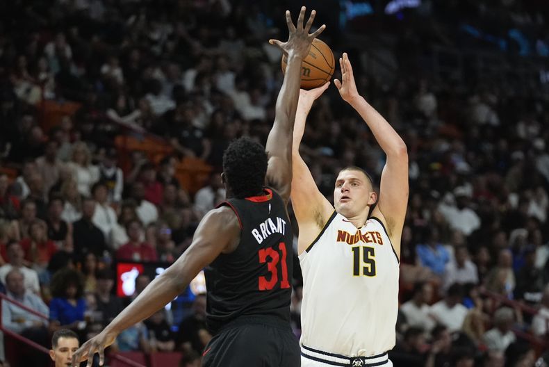 Nikola Jokic (15), de los Nuggets de Dener, intenta un tiro con la marca defensiva de Thomas Bryant (31), del Heat de Miami, durante la primera mitad del juego de baloncesto de la NBA, el miércoles 13 de marzo de 2024, en Miami. (AP Foto/Rebecca Blackwell)