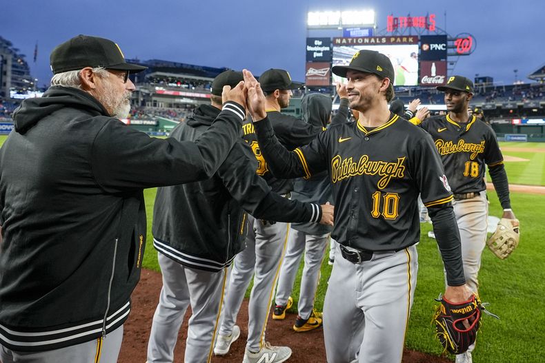 El mánager de los Piratas de Pittsburgh, Derek Shelton, a la izquierda, celebra con Bryan Reynolds después de un partido de béisbol contra los Nacionales de Washington en el Nationals Park, el lunes 1 de abril de 2024, en Washington. (AP Foto/Alex Brandon)