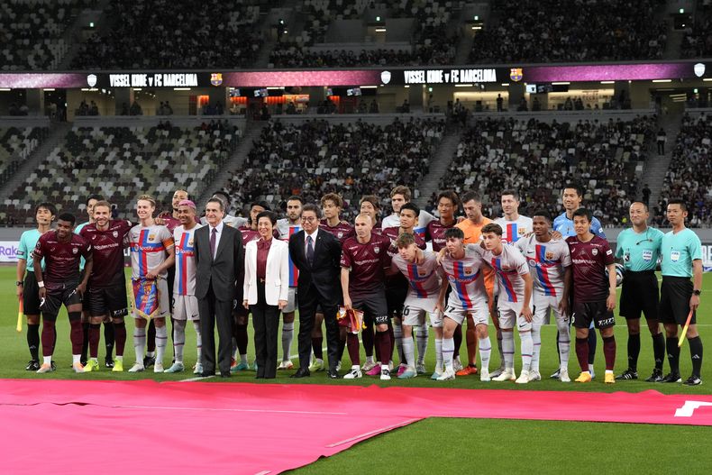 Andres Iniesta del Vissel Kobe posa con jugadores e invitados antes del encuentro amistoso entre el Barcelona y el Vissel Kobe en el Estadio Nacional de Tokio el martes 6 de junio del 2023. (AP Foto/Eugene Hoshiko)