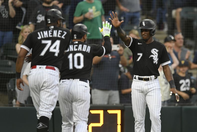 El cubano Yoán Moncada festeja con sus compañeros Tim Anderson y Eloy Jiménez luego de batear un jonrón de tres carreras ante los Atléticos de Oakland, el sábado 26 de agosto de 2023 (AP Foto/Paul Beaty)