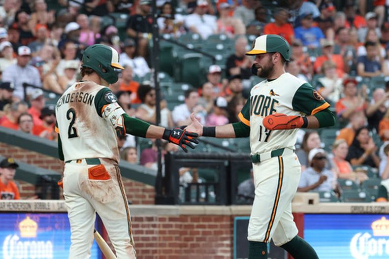 Colton Cowser, de los Orioles de Baltimore (derecha), es recibido por Gunnar Henderson (2) tras anotar gracias a un elevado de sacrificio conectado por Jackson Holliday ante el lanzador de los Padres de San Diego, Griffin Canning, durante la segunda entrada de un partido de béisbol, el viernes 12 de junio de 2026, en Baltimore. (Foto AP/Terrance Williams)