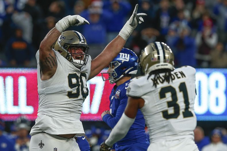 El tackle defensivo de los Saints de Nueva Orleáns Bryan Bresee (90) y el safety Jordan Howden (31) celebran después de que los Giants de Nueva York fallaron un gol de campo al final del último cuarto de un partido de fútbol americano de la NFL, el domingo 8 de diciembre de 2024, en East Rutherford, Nueva Jersey (AP Foto/John Munson)