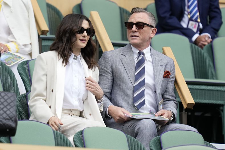 El actor Daniel Craig y su esposa, la actriz Rachel Weisz, se sientan en el palco real de la cancha central para la final de individuales masculinos entre el español Carlos Alcaraz y el serbio Novak Djokovic el día catorce del campeonato de tenis de Wimbledon en Londres, el domingo 16 de julio de 2023. (Foto AP/Kirsty Wigglesworth)