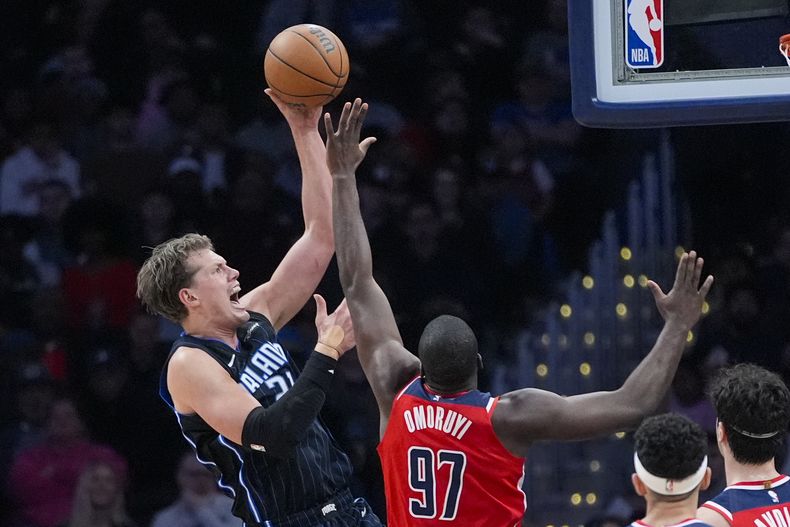 Moritz Wagner, izquierda, del Magic de Orlando, tira sobre Eugene Omoruyi, de los Wizards de Washington, durante la primera mitadl del juego de baloncesto de la NBA, el miércoles 6 de marzo de 2024, en Washington. (AP Foto/Alex Brandon)