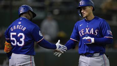 El campocorto de los Rangers de Texas Corey Seager (derecha) celebra junto al cubano Adolis García (53) luego de conectar un jonrón de tres carreras ante los Atléticos de Oakland durante el octavo episodio del juego de béisbol, el lunes 6 de mayo de 2024, en Oakland, California. (AP Foto/Godofredo A. Vásquez)