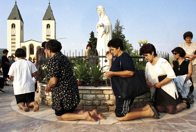 ARCHIVO - Mujeres católicas bosnias rezan durante el feriado de la Asunción en Medjugorje, unos 120 kilómetros (75 millas) al sur de la capital bosnia, Sarajevo, el 15 de agosto de 2000. (AP Foto/Hidajet Delic, Archivo)