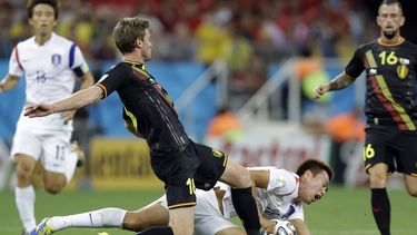 americateve | Nicolas Lombaerts, de B&eacute;lgica, patea el bal&oacute;n mientras el surcoreano Kim Shin-wook cae durante el encuentro de la Copa del Mundo realizado el jueves 26 de junio de 2014, en Sao Paulo (AP Foto/Kirsty Wigglesworth)
