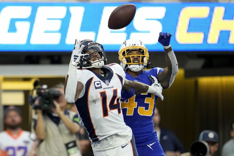 Courtland Sutton (14), wide receiver de los Broncos de Denver, estira el brazo derecho para atrapar un pase de anotación con la presión del cornerback Michael Davis (43), de los Chargers de Los Ángeles, durante la segunda mitad del juego de la NFL, el domingo 10 de diciembre de 2023, en Inglewood, California. (AP Foto/Marcio Jose Sanchez)