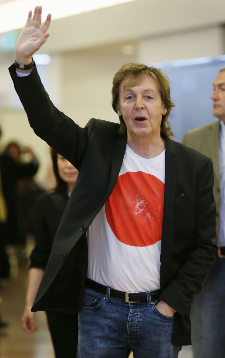 Paul McCartney saluda al llegar al Aeropuerto Internacional de Haneda, en Tokio, el jueves 15 de mayo de 2014. El cantante cancel&oacute; su presentaci&oacute;n del s&aacute;bado 17 en la capital japonesa debido a un virus, pero prometi&oacute; reponerla