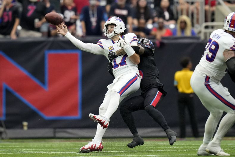 Josh Allen (17), quarterback de los Bills de Buffalo, es derribado por el safety Jalen Pitre, de los Texans de Houston, mientras lanza un pase durante la segunda mitad de fútbol americano de la NFL, el domingo 6 de octubre de 2024, en Houston. (AP Foto/Eric Gay)