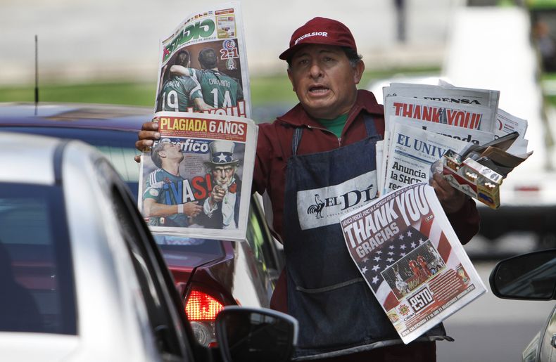 Joel Marquez vende peri&oacute;dicos que en sus portadas llevan titulares de agradecimiento a Estados Unidos por su victoria 3-2  frente a Panam&aacute; que permiti&oacute; a la selecci&oacute;n mexicana mantener vivas sus esperanzas de clasificar a la Co