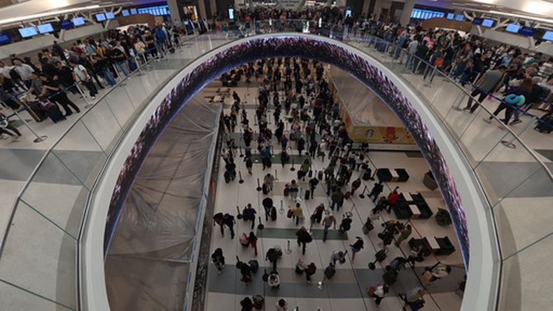 Viajeros hacen fila para pasar los controles de seguridad en el Aeropuerto Intercontinental George Bush en Houston, el 26 de marzo de 2026. (AP Foto/Lekan Oyekanmi)