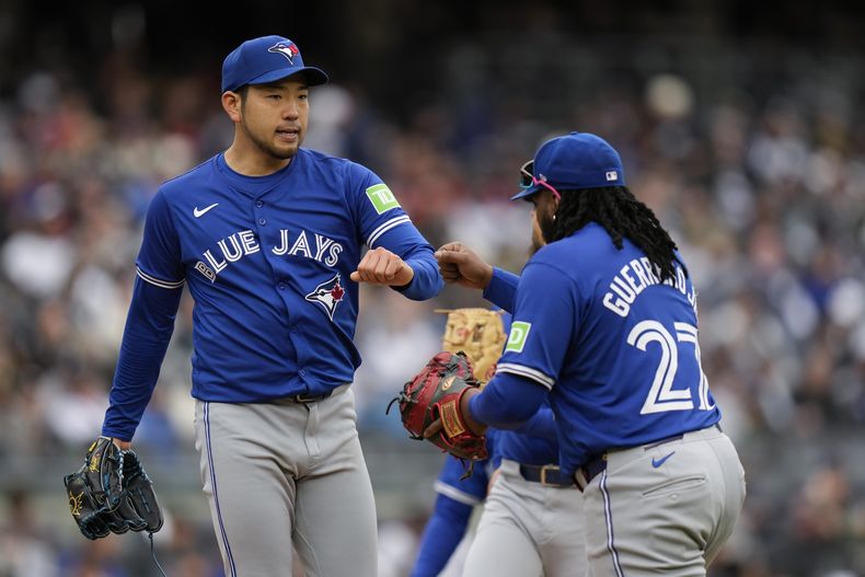El lanzador de los Azulejos Yusei Kikuchi saluda al dominicano Vladimir Guerrero Jr. a su salida del juego en la sexta entrada ante los Yankees de Nueva York el viernes 5 de abril del 2024. (AP Foto/Seth Wenig)