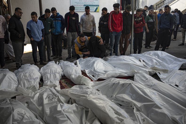 Palestinos lloran a sus familiares que murieron en los bombardeos israelíes contra la Franja de Gaza, en el hospital de Rafah, Gaza, el martes 12 de diciembre de 2023. (AP Foto/Fatima Shbair)