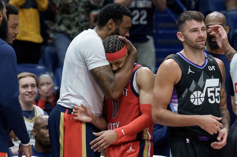 El pívot de los Pelicans de Nueva Orleans, DeAndre Jordan, abraza al base de los Pelicans, Jeremiah Fears (0), durante la segunda mitad luego de que Fears anotara 40 puntos contra el Jazz de Utah, incluyendo al base de los Jazz, John Konchar (55), durante un partido de baloncesto de la NBA en Nueva Orleans, el martes 7 de abril de 2026. (AP Foto/Matthew Hinton)