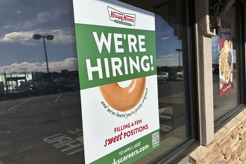 ARCHIVO - Un anuncio de contrataciones es exhibido en la ventana de una tienda de la cadena de donas Krispy Kreme el 19 de noviembre de 2024, en Lone Tree, Colorado. (AP Foto/David Zalubowski, Archivo)