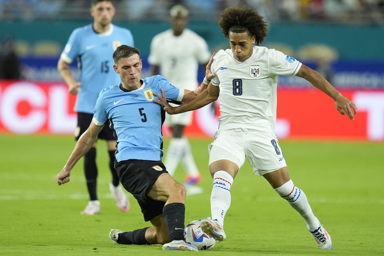 Adalberto Carrasquilla, de Panamá, a la derecha, y Manuel Ugarte, de Uruguay, luchan por el balón durante un partido por el Grupo C de la Copa América en Miami Gardens, Florida, el domingo 23 de junio de 2024. (Foto AP/Rebecca Blackwell)