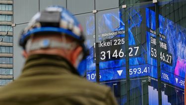 Una persona se encuentra frente a una pantalla electrónica que muestra el índice Nikkei de Japón en una correduría de valores el jueves 2 de abril de 2026, en Tokio. (AP Foto/Eugene Hoshiko)