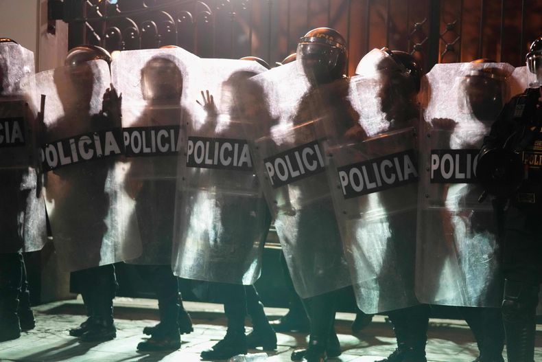 La silueta de varios agentes de la policía se recorta sobre una barricada en llamas durante un enfrentamiento con manifestantes antigubernamentales, en una protesta contra las políticas sociales y económicas de la presidenta, Dina Boluarte, en Lima, Perú, el 28 de septiembre de 2025. (AP Foto/Martín Mejía)