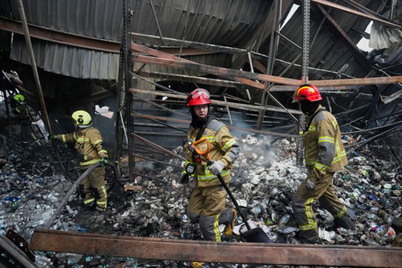 Bomberos combaten un incendio después de que un misil ruso alcanzara un almacén de alimentos cerca de Kiev, Ucrania, el miércoles 5 de agosto de 2026. (AP Foto/Efrem Lukatsky)