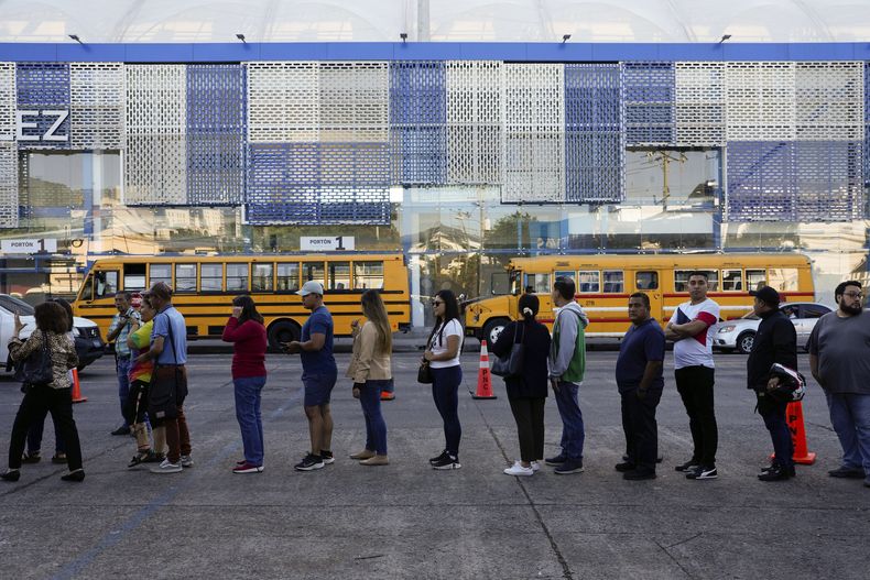Electores hacen fila en un centro de votación durante las elecciones generales, el domingo 4 de febrero de 2024, en San Salvador, El Salvador. (AP Foto/Moisés Castillo)