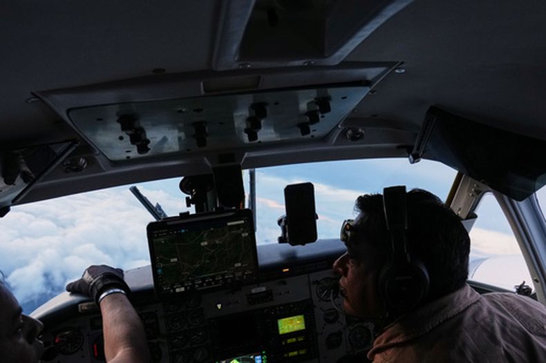 Los pilotos Víctor Torres de México (d) y José Torres de Honduras vuelan una avioneta para crear lluvia, parte de los esfuerzos del gobierno hondureño por contrarrestar la sequía en el río Aguan en el norte de Honduras, el 14 de octubre del 2026. (AP foto/Moisés Castillo)