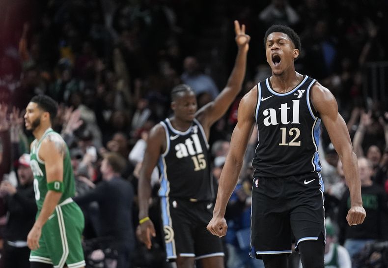 DeAndre Hunter (12), de los Hawks de Atlanta, reacciona después de atinar un triple al final de la segunda mitad del juego de baloncesto de la NBA en contra de los Celtics de Boston, el lunes 25 de marzo de 2024, en Atlanta. (AP Foto/John Bazemore)