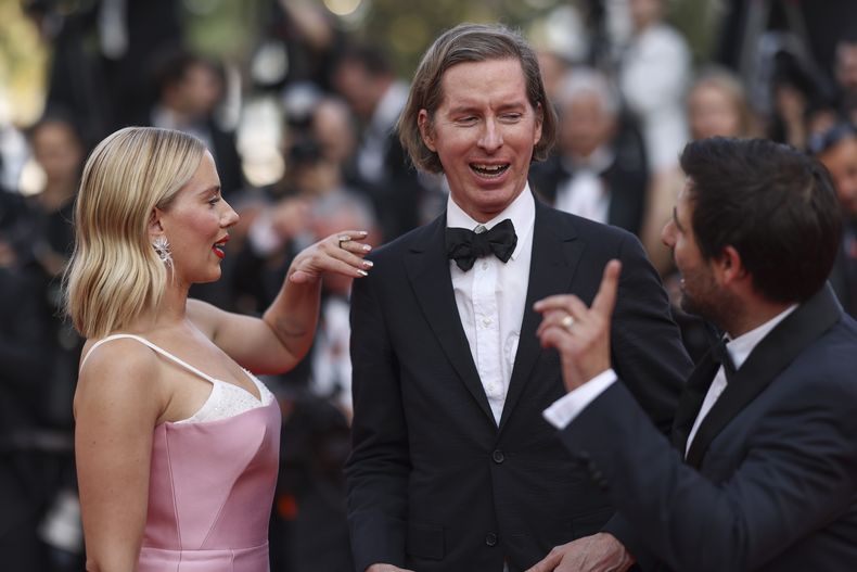Scarlett Johansson, de izquierda a derecha, el director Wes Anderson y Jason Schwartzman posan a su llegada a al estreno de la película Asteroid City en la 76a edición del festival internacional de cine de Cannes, en el sur de Francia, el martes 23 de mayo de 2023. (Foto Vianney Le Caer/Invision/AP)