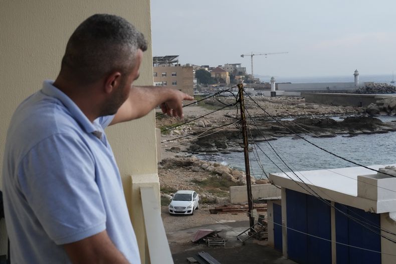 Un hombre libanés señala hacia una playa en Batroun, Líbano en que, según funcionarios, hombres armados se llevaron a un capitán de un buque, el 2 de noviembre del 2024. (Foto AP/Hussein Malla)