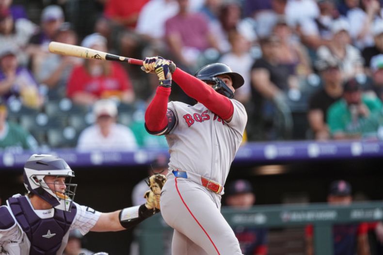 Wilyer Abreu, de los Medias Rojas de Boston, sigue la trayectoria de su triple productor ante el lanzador abridor de los Rockies de Colorado, Sean Sullivan, durante la primera entrada de un partido de béisbol, el martes 23 de junio de 2026, en Denver. (Foto AP/David Zalubowski)
