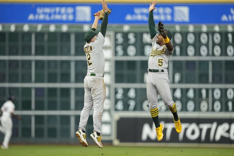 Tony Kemp y Nick Allen, de los Atléticos de Oakland, festejan tras la victoria sobre los Astros de Houston, el martes 12 de septiembre de 2023 (AP Foto/David J. Phillip)