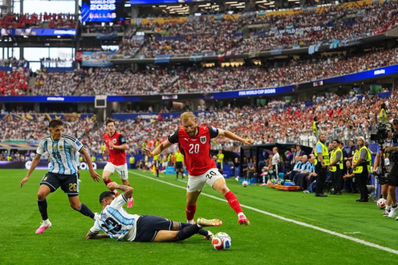 El defensor de Argentina, Cristian Romero (13) intenta frenar el avance de Konrad Laimer, de Austria, durante un partido del Grupo J del Mundial en Arlington, Texas, el lunes 22 de junio, 2026. (AP Foto/Julio Cortez)