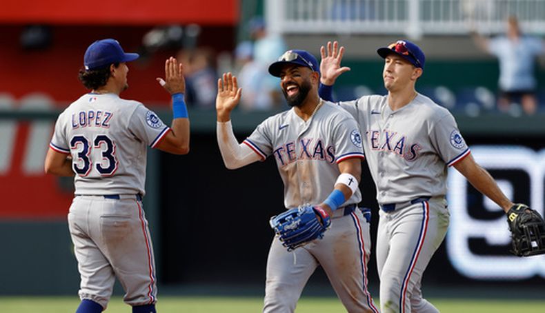 Nicky Lopez (33), Ezequiel Durán (centro) y Wyatt Langford (derecha), de los Rangers de Texas, celebran al final de un partido de béisbol contra los Reales de Kansas City, en Kansas City, Misuri, el jueves 11 de junio de 2026. (Foto AP/Colin E. Braley)