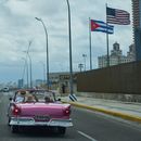 Un auto clásico estadounidense lleva a turistas junto a la embajada de Estados Unidos en La Habana, el lunes 20 de abril de 2026. (AP Foto/Ramón Espinosa)