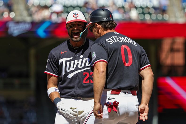 Royce Lewis de los Mellizos de Minnesota celebra con el coach de primera base Grady Sizemore su sencillo remolcador en la séptima ante los Cardenales de San Luis el domingo 14 de junio del 2026. (AP Foto/Ellen Schmidt)