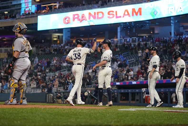 Matt Wallner (38) de los Mellizos de Minnesota celebra junto a Max Kepler (centro) luego de impactar un grand slam ante los Atléticos de Oakland durante el juego en Mineápolis. Martes 26 de septiembre de 2023. (AP Foto/Abbie Parr)