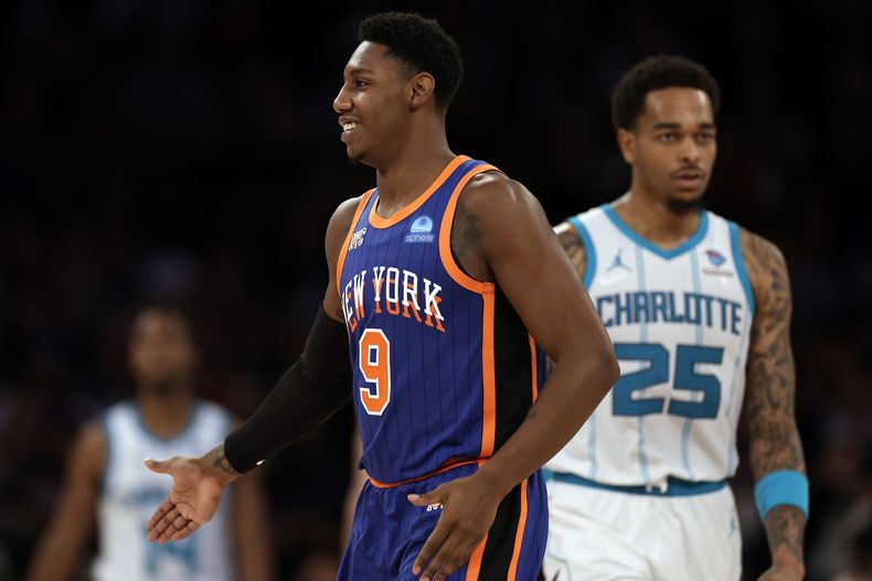 El escolta de los Knicks de Nueva York RJ Barrett (9) reacciona frente al alero de los Hornets de Charlotte P.J. Washington durante la segunda mitad del juego de la NBA, el domingo 12 de noviembre de 2023, en Nueva York. (AP Foto/Adam Hunger)