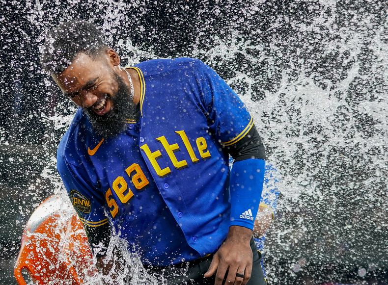 El dominicano Teoscar Hernández, de los Marineros de Seattle es empapado con la hielera tras batear el hit decisivo en el encuentro de viernes 21 de julio de 2023, ante los Azulejos de Toronto (AP Foto/Lindsey Wasson)